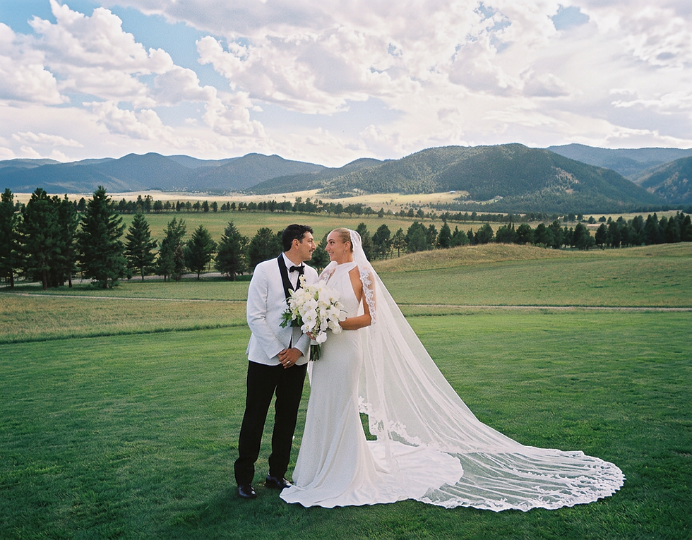 - Bride and groom celebrating their Colorado wedding with mountain views at Spruce Mountain Ranch.
