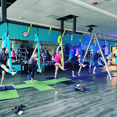 Aerial Yoga class trying new fitness stretch Fitness Inspired Studio