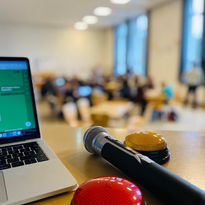 Rechner und Mikrofon vor Schulklasse