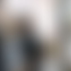 Four people collaborate at a whiteboard covered in sticky notes. One writes with a red marker, creating a focused, creative atmosphere.