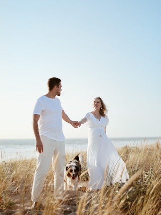 photo grossesse d'un couple dans les dunes avec chien