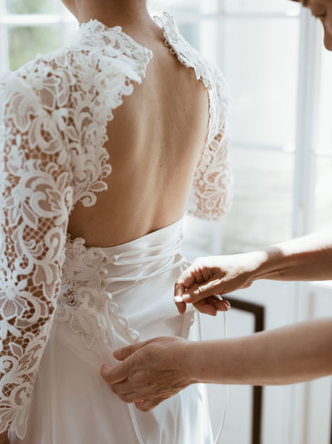 photo details du dos de la robe de la mariée durant les preparatifs