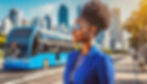 Mulher negra, com ônibus fretado ao fundo