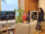 Person with a neurofeedback cap on, in front of a screen with brain maps