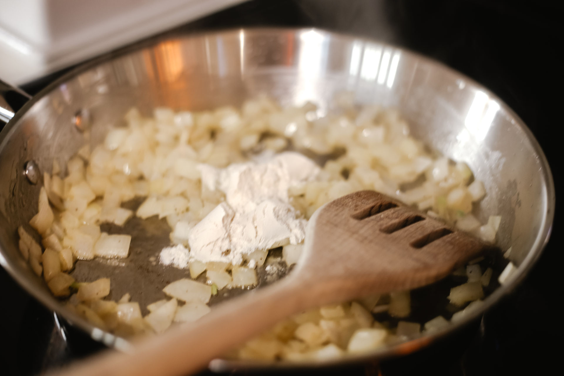Flour added to sauteed onions in pan.