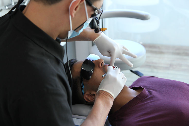 Male dentist inspecting the teeth of a male patient
