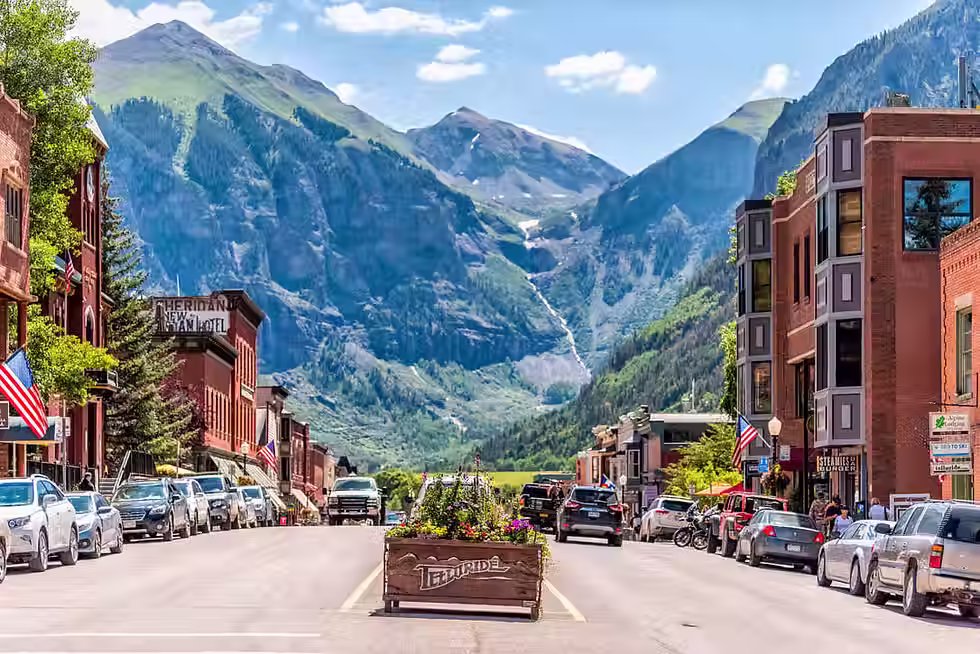 The beautiful shot from downtown Telluride, Colorado toward the mountain range with a waterfall in the distant background