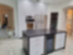 Luxury custom kitchen with white cabinets and dark island.