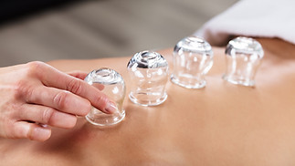 Therapist Placing Transparent Glass Cups On Person's Back In Spa.jpg