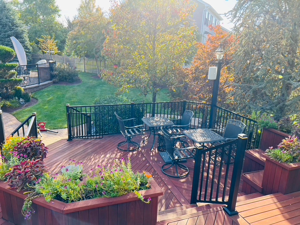 View of wood deck with outdoor furniture and built in benches and railing.