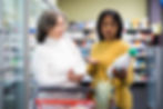 Two people at a grocery store trying to choose between items.