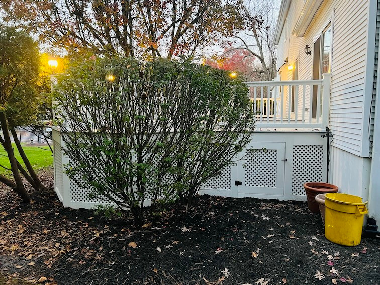 Illuminated evening deck with integrated shrubbery highlighting Util Construction's outdoor space solutions in New Jersey.