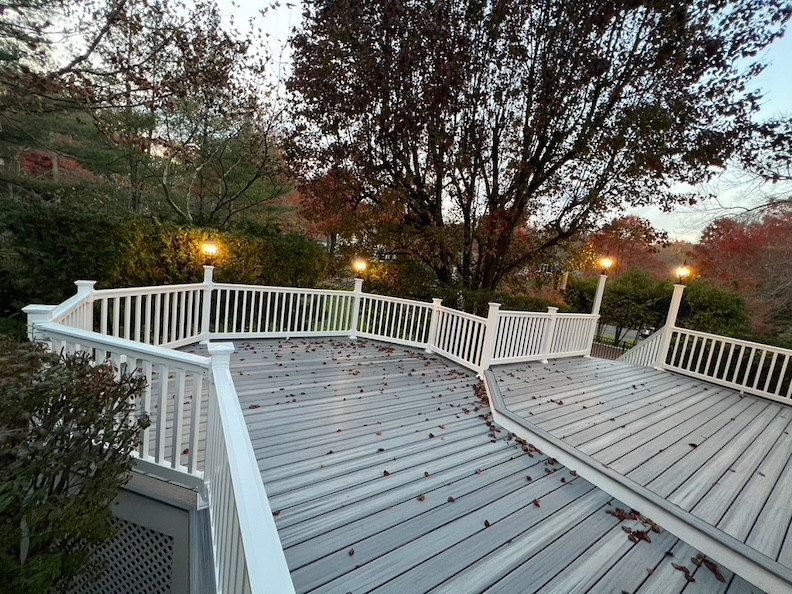 Evening view of a serene deck in New Jersey with integrated lighting and autumn leaves.