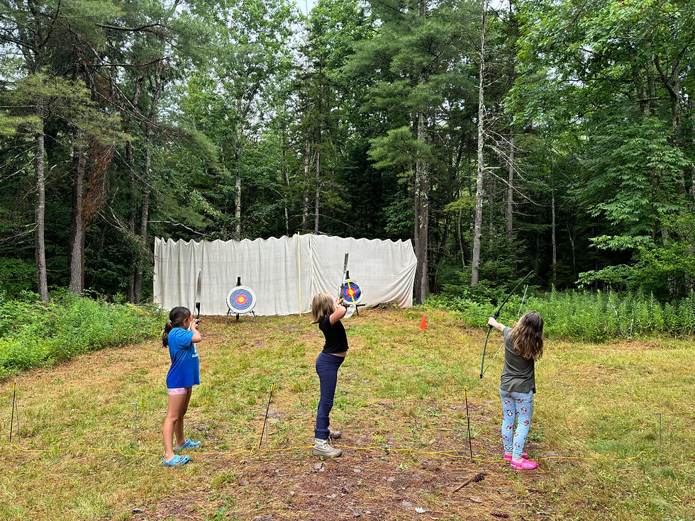 3 girls shooting arrows at the archery range