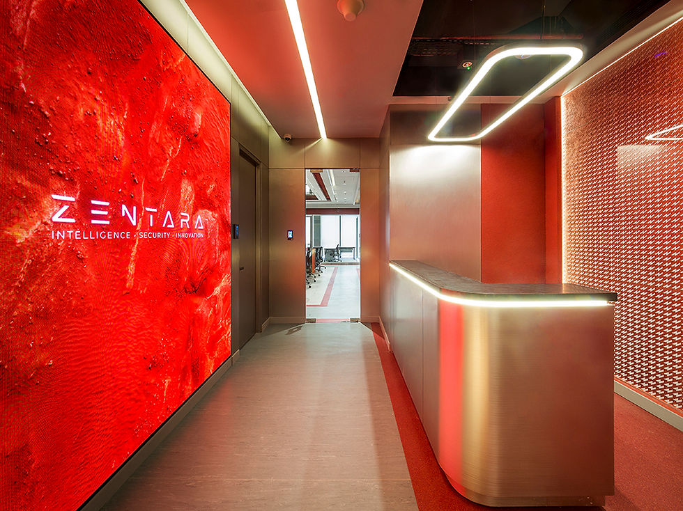 Lobi kantor modern bernuansa merah dengan meja resepsionis metalik dan dinding bertuliskan ZENTARA Intelligence | Security | Innovation