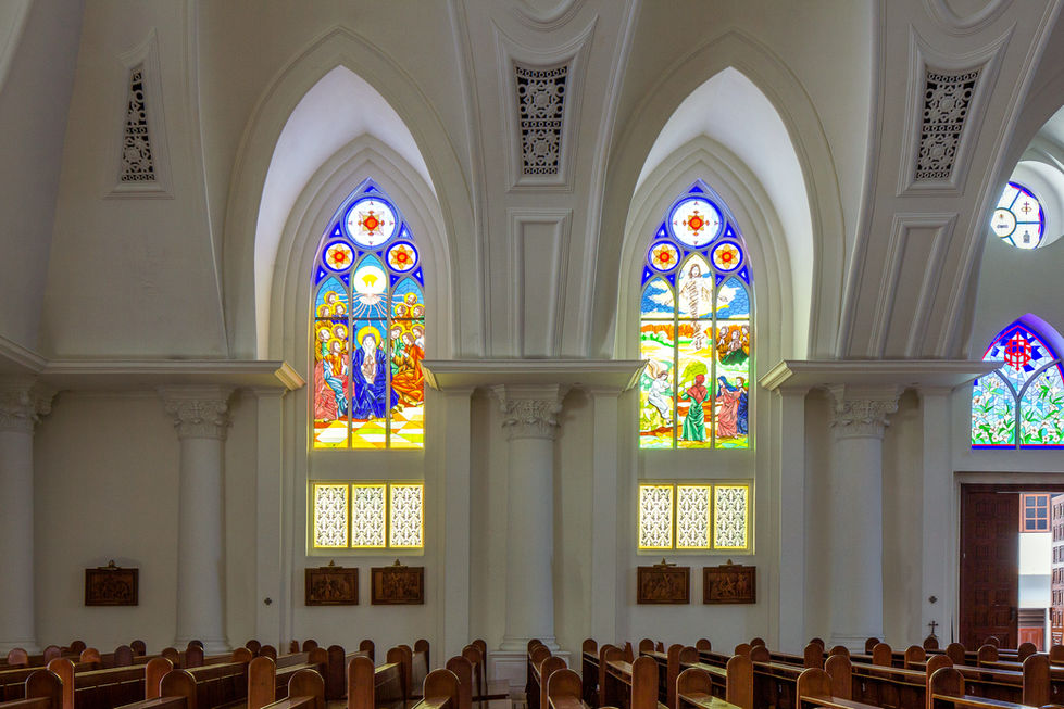 Stained-glass windows illuminating the nave of Cathedral Santa Maria Manado