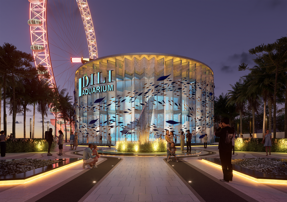 Illuminated circular aquarium building at night featuring fish projections, with a large glowing Ferris wheel in the background.