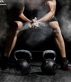 Weightlifter clapping hands and preparing for workout at a gym. Focus on dust.jpg