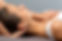 Detail of young woman at osteopathic treatment session. Therapist manipulating neck and ch
