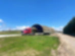 Red truck performing a building relocation nz of a shed