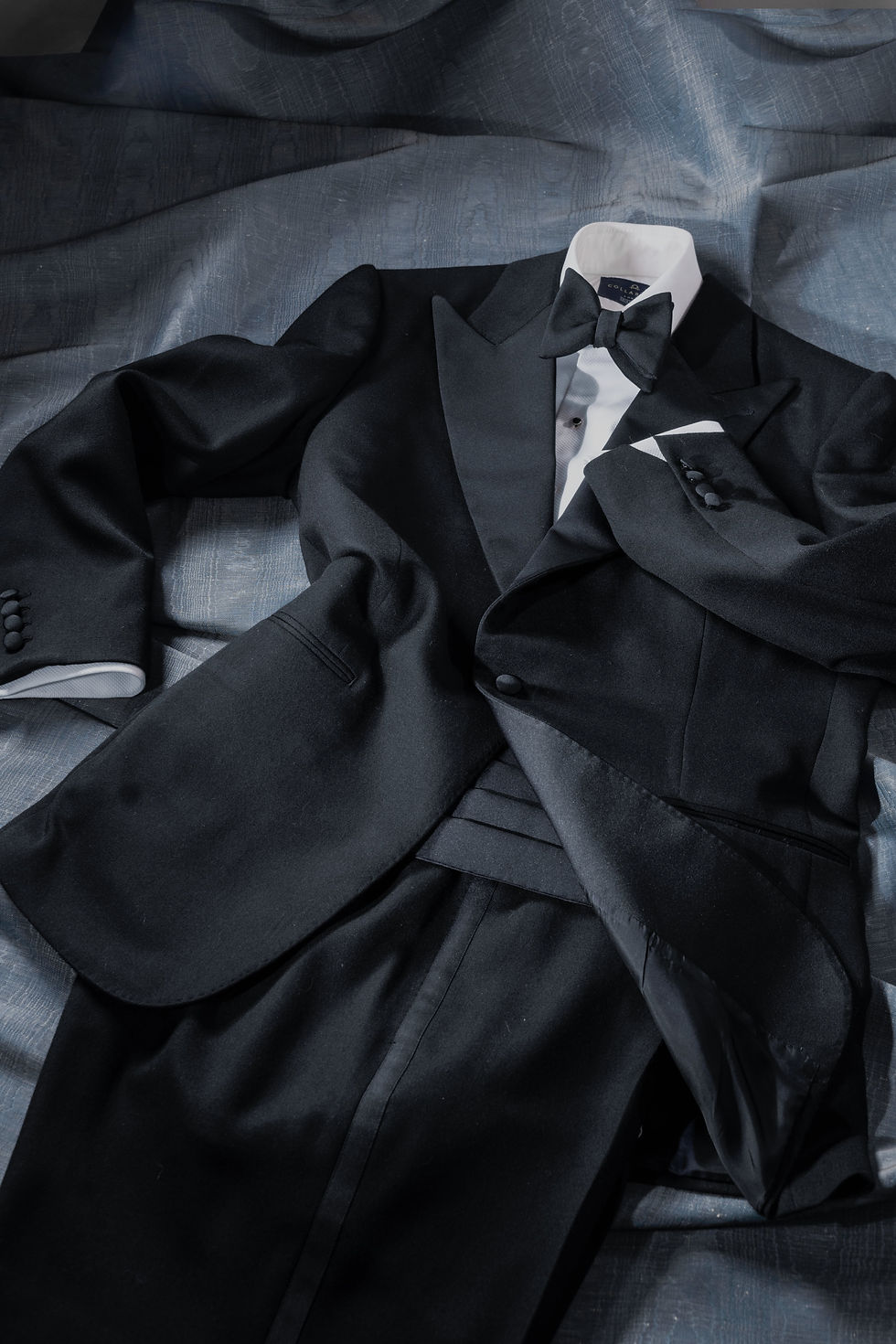 Single-breasted tuxedo in wool barathea and satin facing, with matching bowtie and cummerbund.
