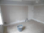 Before pic of stripped back bedroom with bare plaster walls and floorboards
