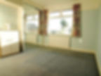 Before pic of old bedroom with grey carpet and dated decor