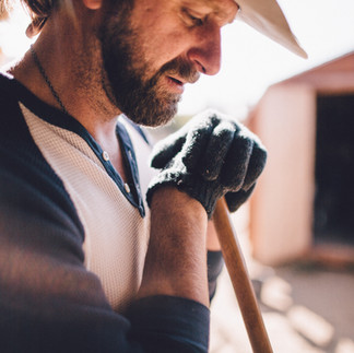 worker leaning on wooden handle
