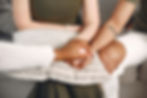Close-up of a therapist holding hands with parents, symbolizing compassion, validation, and support in processing NICU-related trauma and grief.