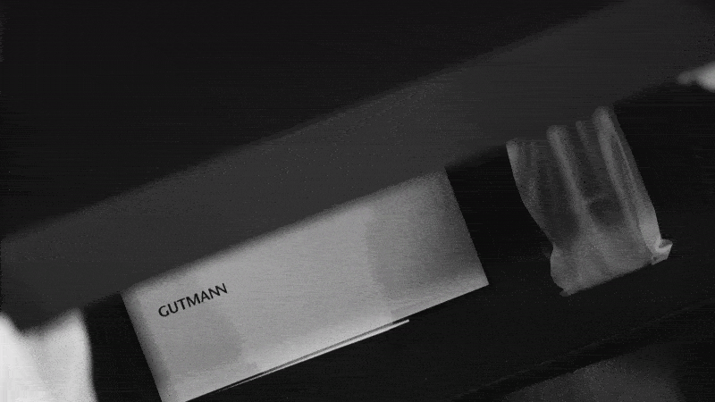 GIF de el welcome pack Gutmann: con el manual de instrucciones, el mando a distancia y el logo y el claim en la caja: Gutmann. Your home, your temple. 