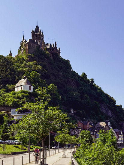 A huge castle over a riverside in the sunshine