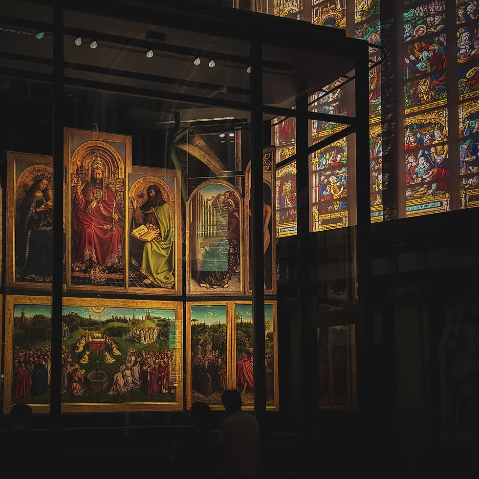 Exhibit with religious paintings in glass case, vibrant stained-glass window background, two silhouetted people observing quietly.
