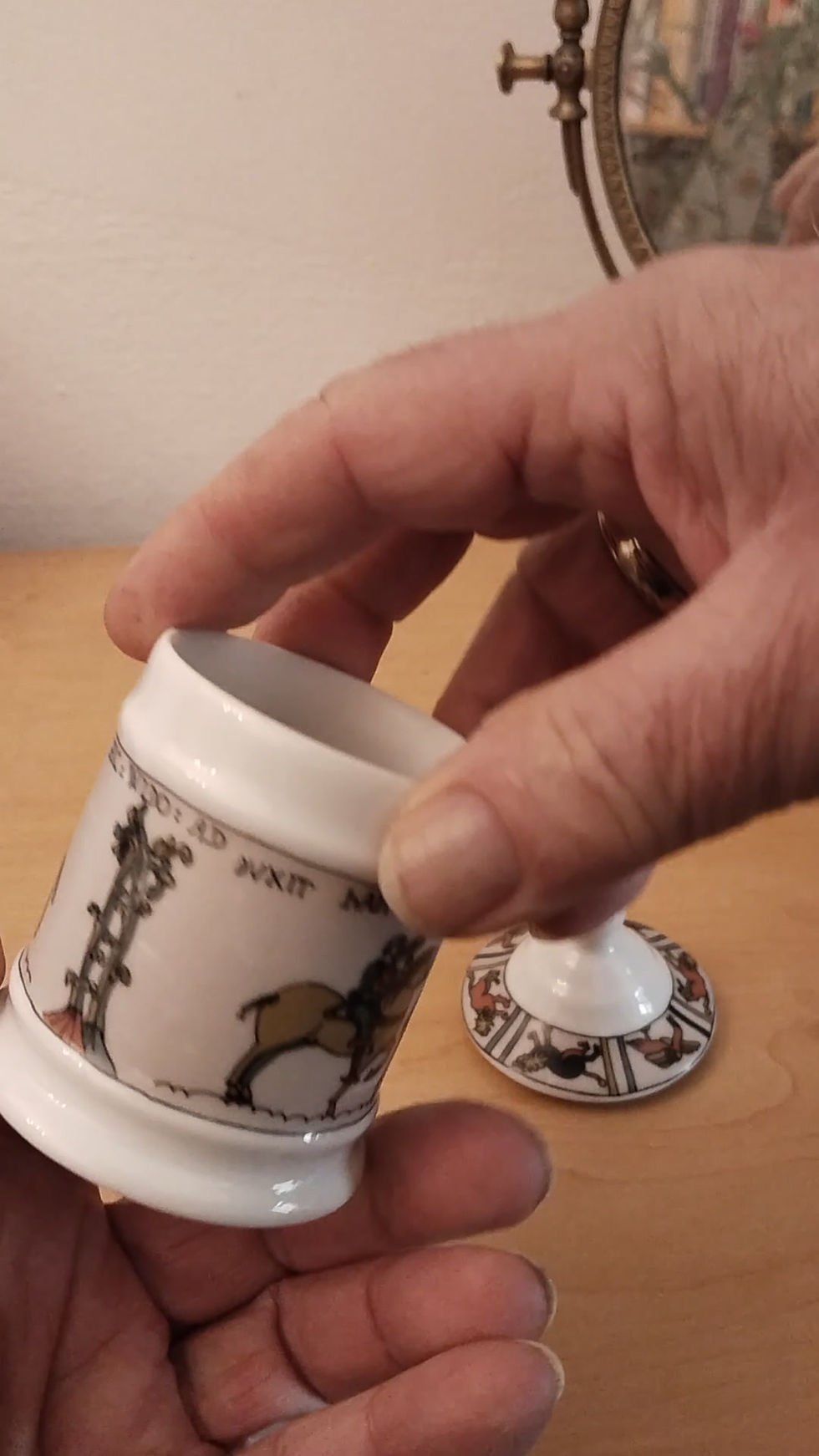 Thumbnail: Video:Weiße Porzellandose mit spitz zulaufendem Deckel, verziert mit mittelalterlichen Reiterszenen und Fabelwesen.