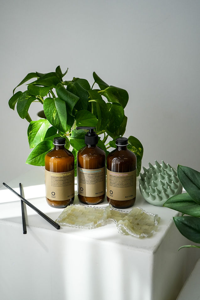 Three amber bottles, green plant, reusable pads, and diffusers