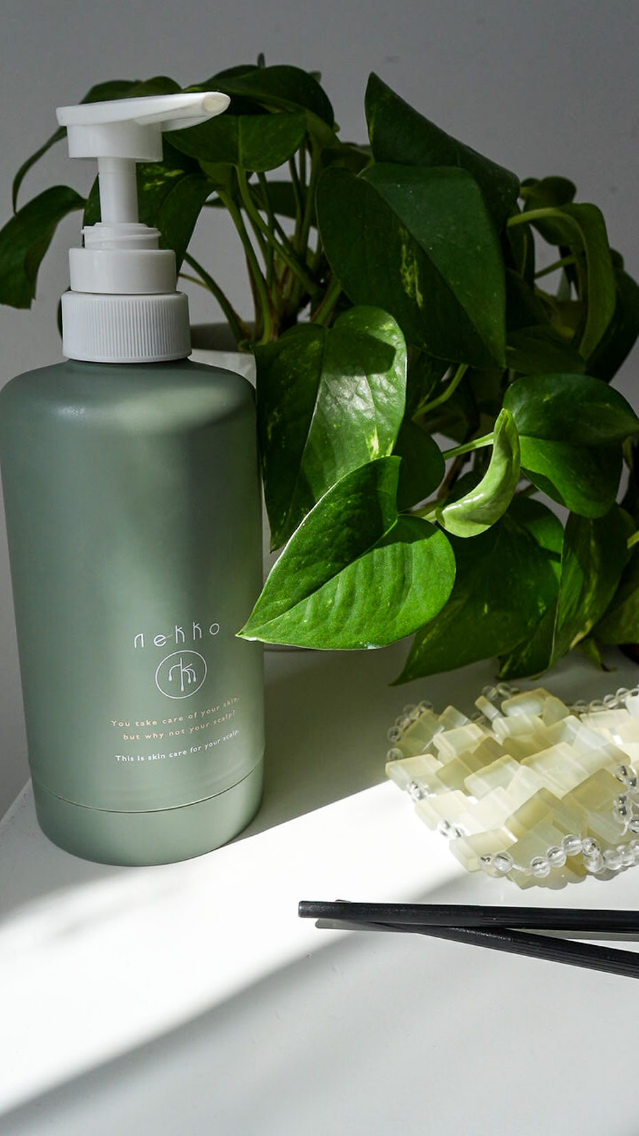 Green pump bottle with botanical leaves and textured product