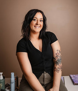 Lauren smiling and sitting on a desk