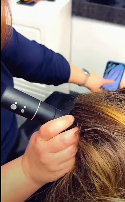 A person sitting and gwtting a scalp assesment from a Solari Head Spa professional befor a scalp treatment
