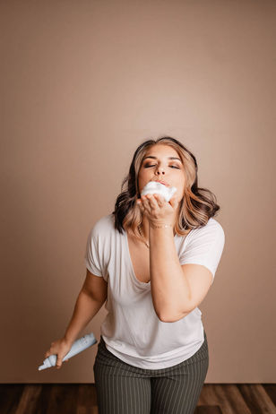 Ashley R playfully blowing mousse from her hands.