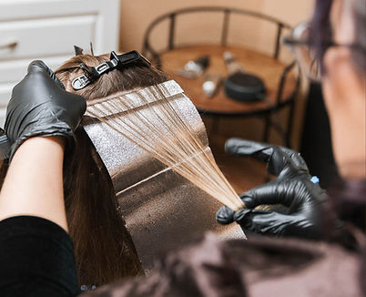 Solari Head Spa Stylist adding highlights to colored hair.