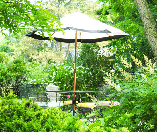 Charming outdoor patio at All Suites Whitney Manor's Chapel, surrounded by lush greenery.