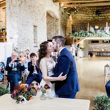 Bride and groom share a first kiss at Priston Mill wedding in Somerset