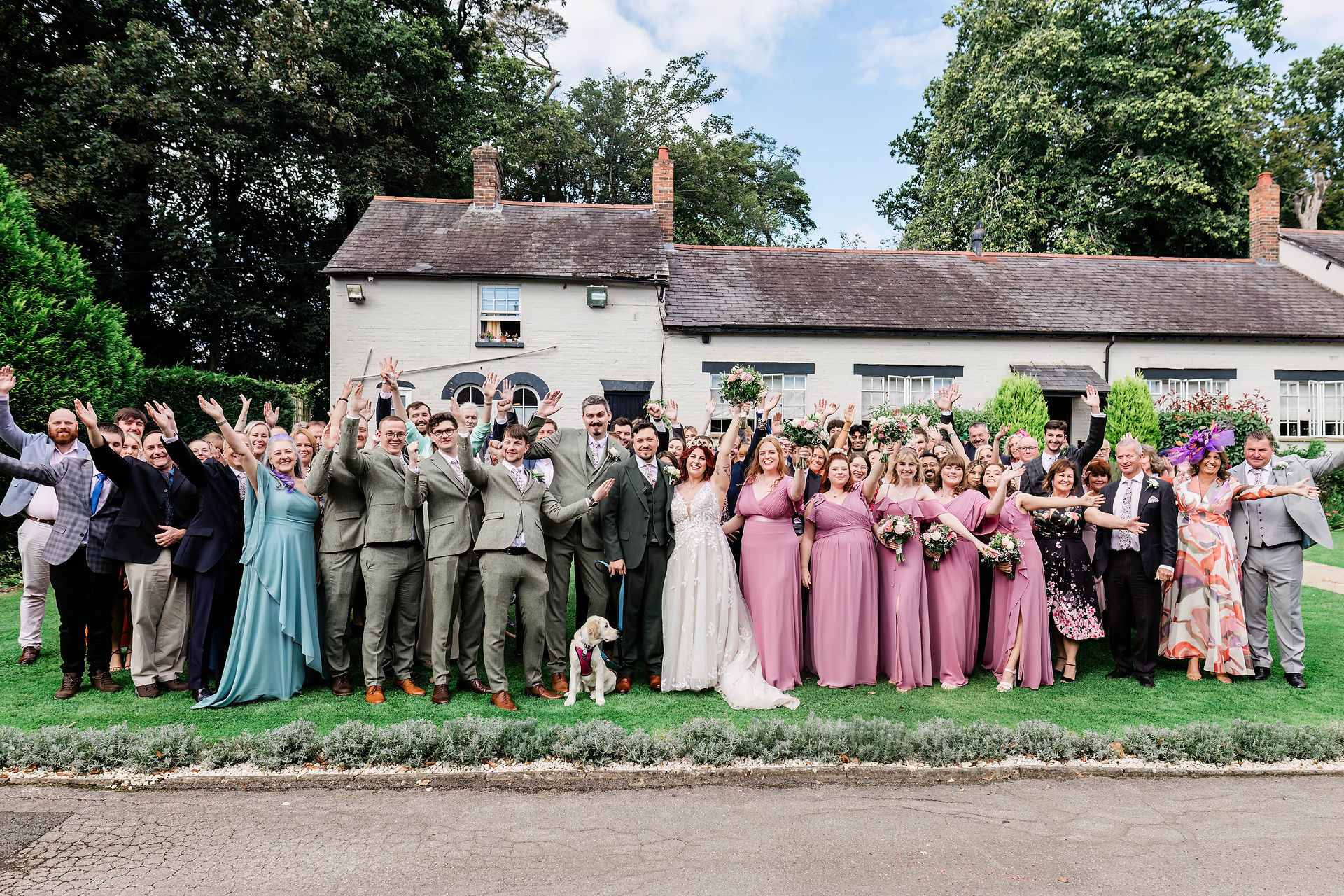 Large wedding group cheering at Burley Manor