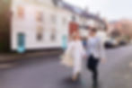 Couple walking down a quiet street in Chelsea, London with bride and groom kissing at the front