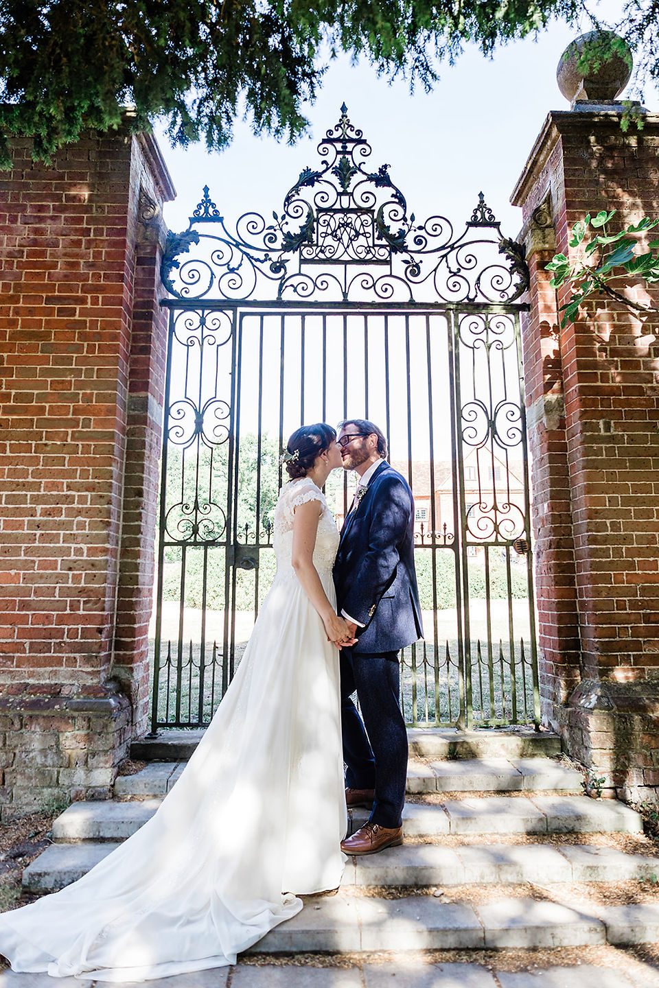 Couple kissing in front of gates at Ufton Court wedding
