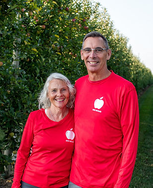 two adults in an orchard