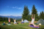 Group of people doing yoga pose outdoor in camping in the mountains. Adults and children s