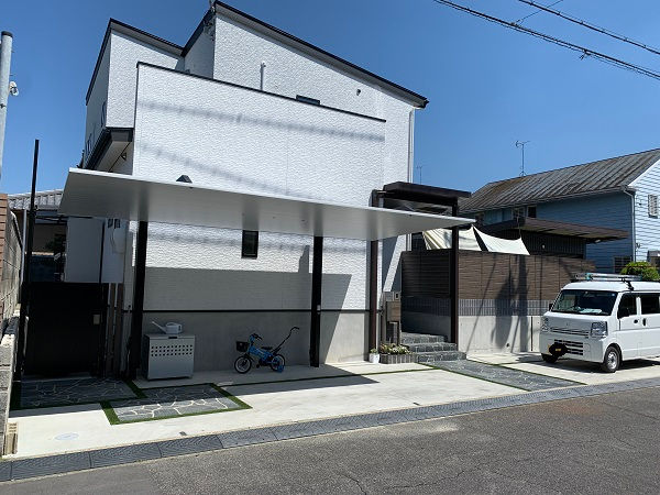 戸建て建物にカーポートとテラスが付いた駐車場