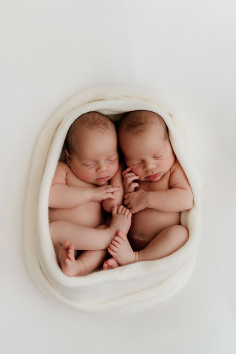 newborn baby twins wrapped in a towel together