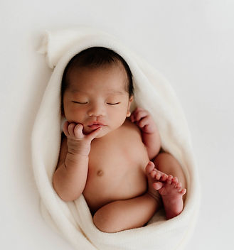 newborn baby sleeping in white towel