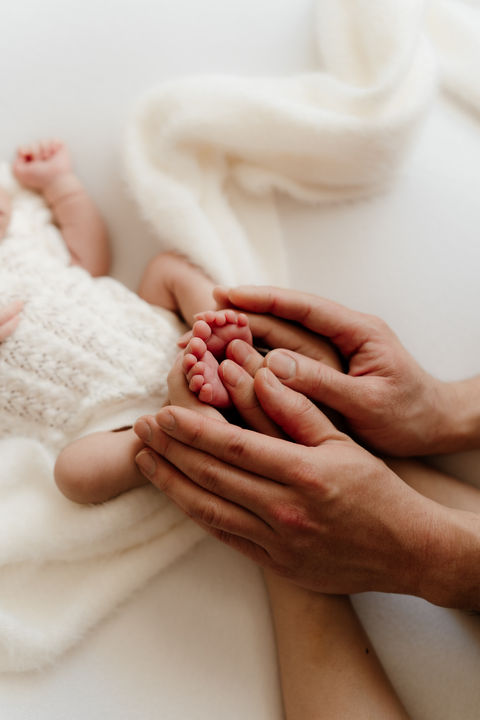 touching the feet of newborn child